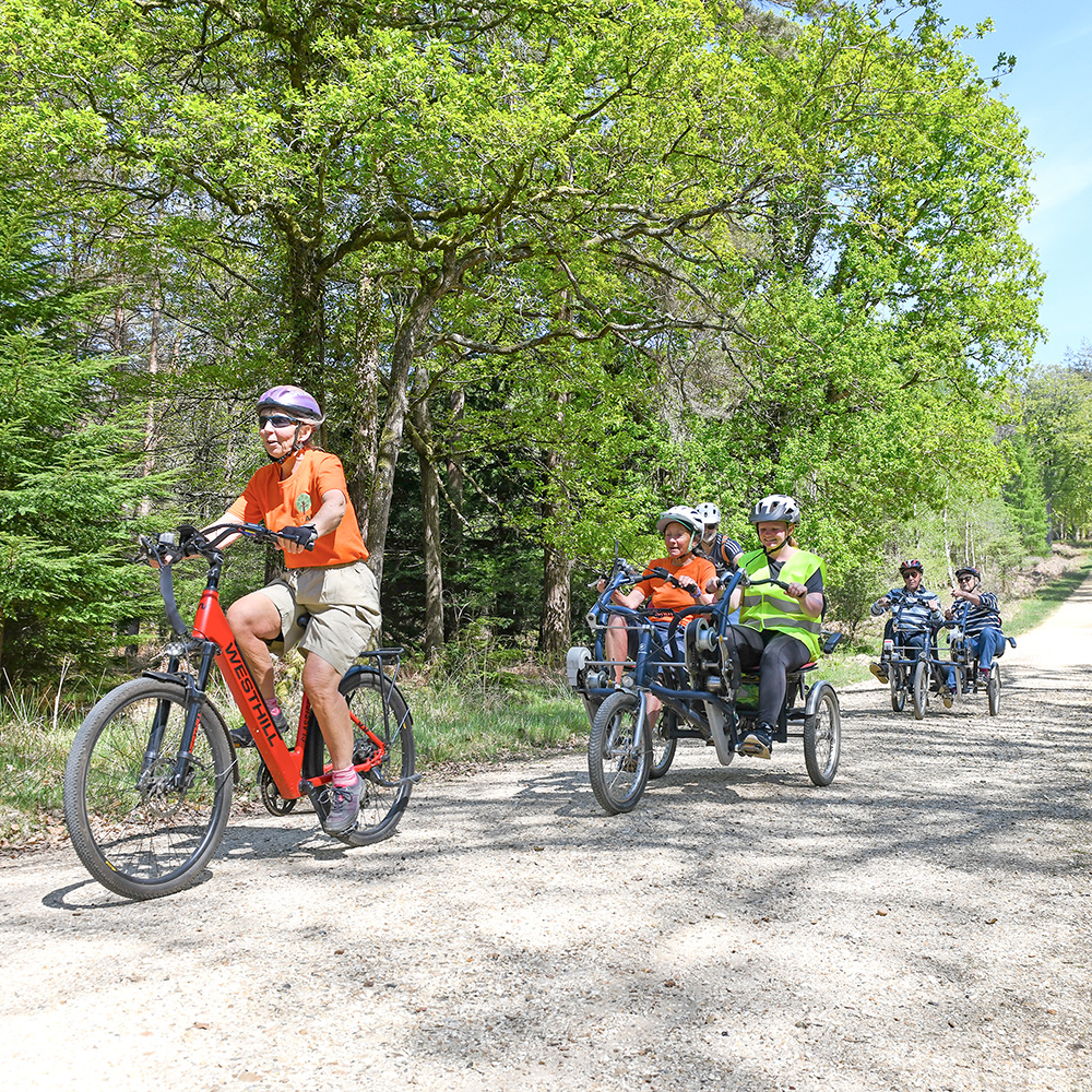 Mountain biker leading a group of cyclists on tandem bikes